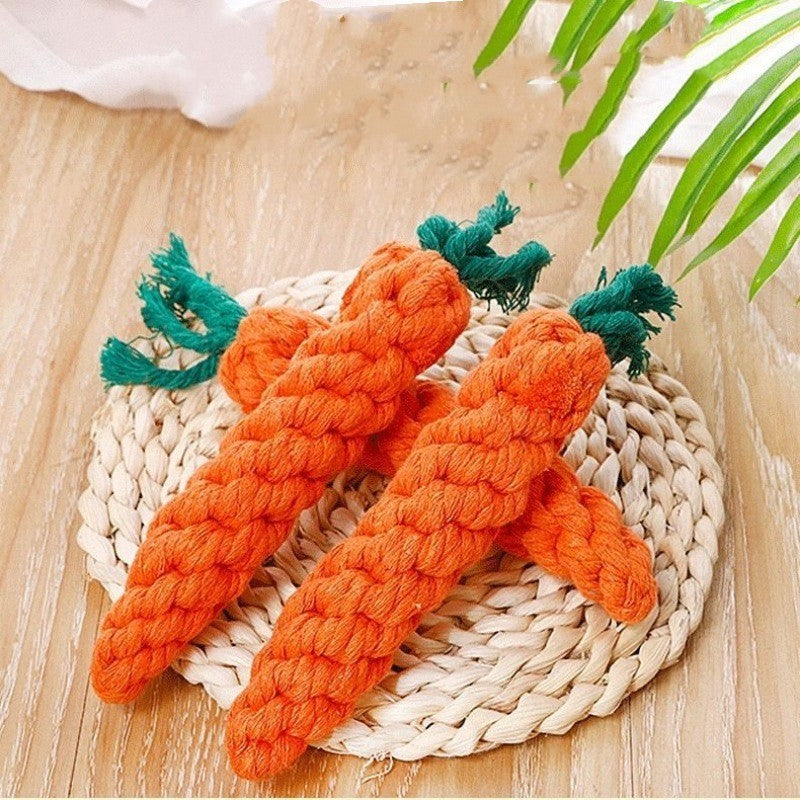 Two orange carrot-shaped rope toys on a woven mat with a wooden background.