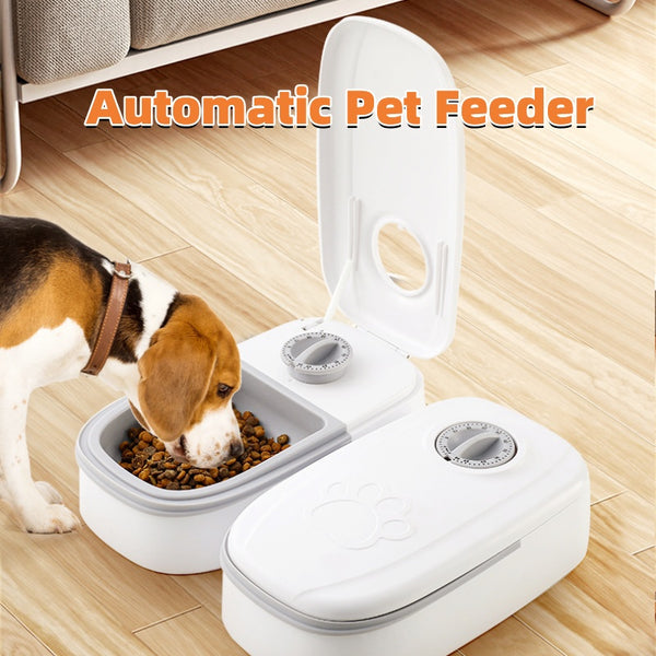 Automatic pet feeder with a dog eating from it on a wooden floor.